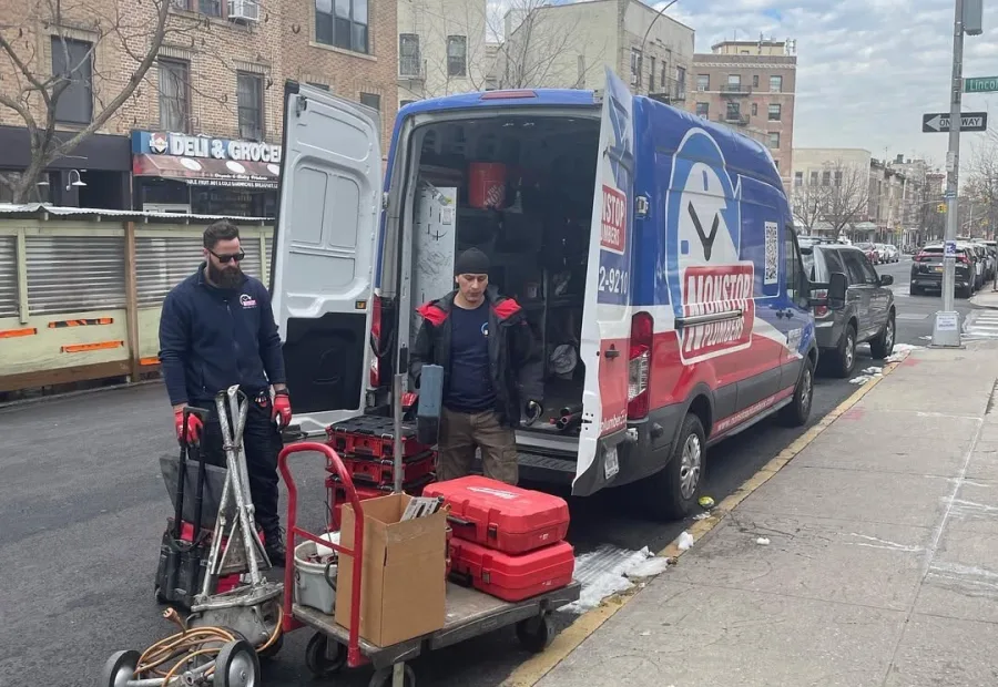 Nonstop Plumbers NY crew unloading tools from a service van on a New York street.